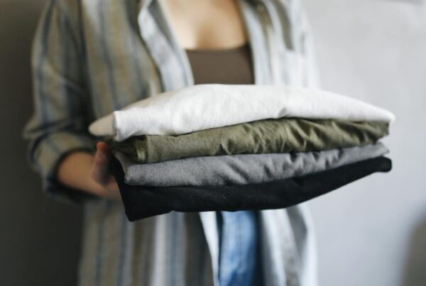 Folded stack of multi-color cotton t-shirts representing well-cared-for custom apparel